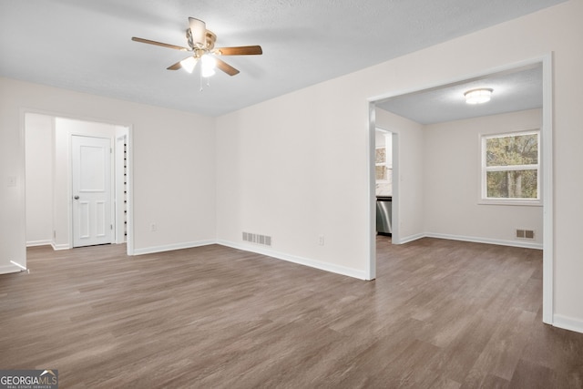 unfurnished room featuring ceiling fan, wood-type flooring, and a textured ceiling