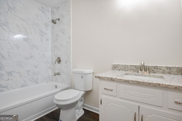 full bathroom featuring vanity, hardwood / wood-style flooring, toilet, and tiled shower / bath combo