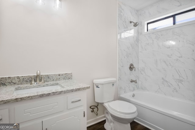 full bathroom featuring hardwood / wood-style floors, vanity, toilet, and tiled shower / bath