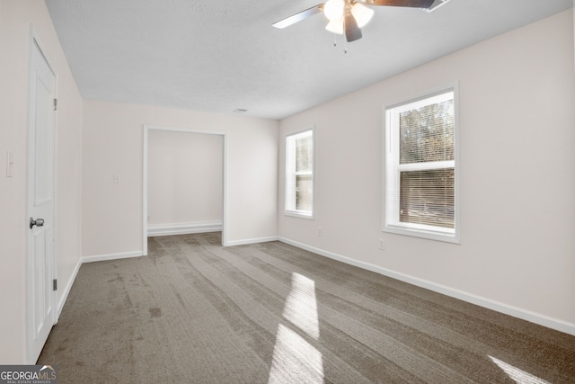 carpeted spare room with ceiling fan