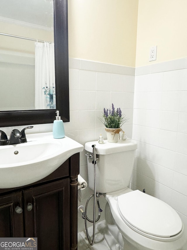 bathroom featuring crown molding, vanity, tile walls, and toilet