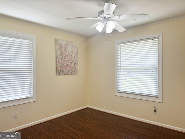 empty room featuring ornamental molding, ceiling fan, and dark wood-type flooring