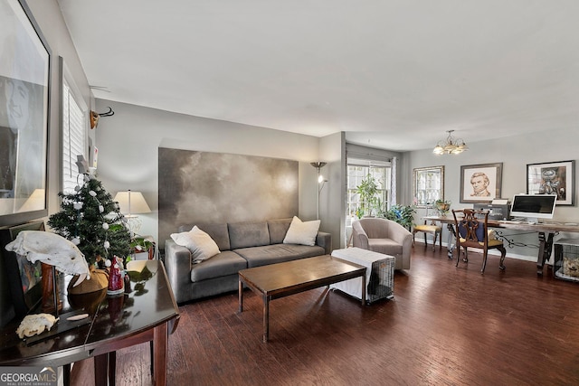 living room featuring dark wood-type flooring and an inviting chandelier