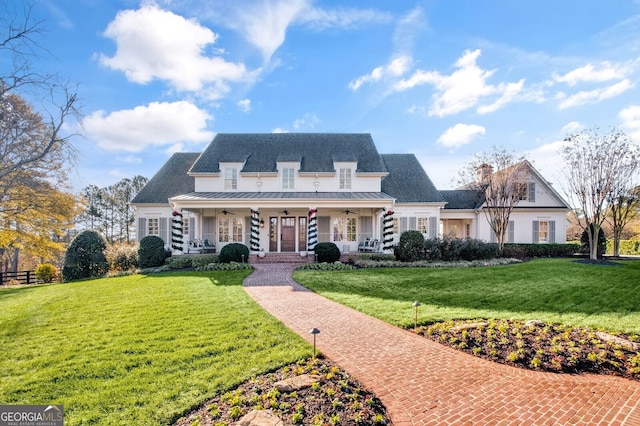 new england style home featuring a front lawn and ceiling fan