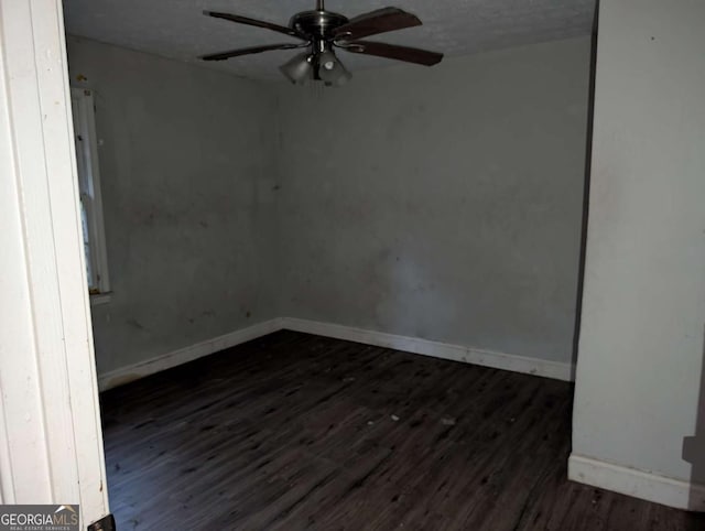 unfurnished room featuring a textured ceiling, ceiling fan, and dark wood-type flooring