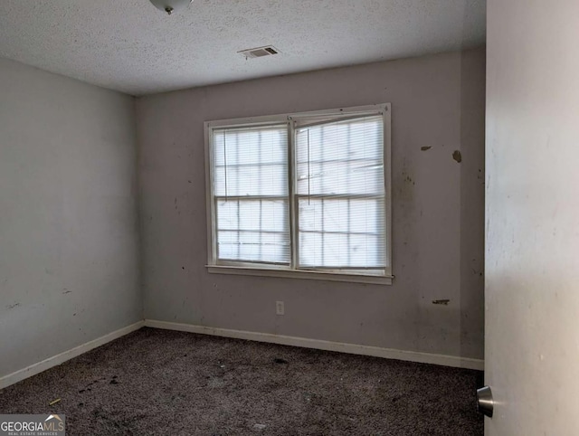 carpeted spare room with a textured ceiling