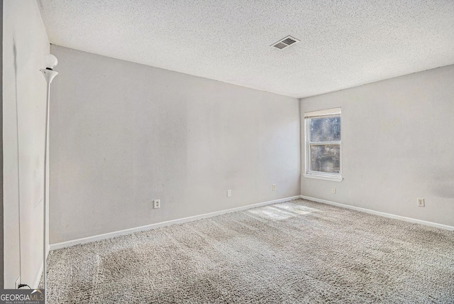 unfurnished room with baseboards, a textured ceiling, visible vents, and carpet flooring