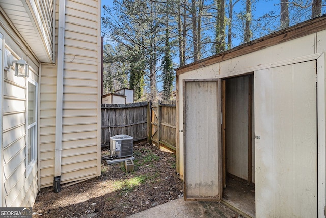 view of shed with fence and central air condition unit