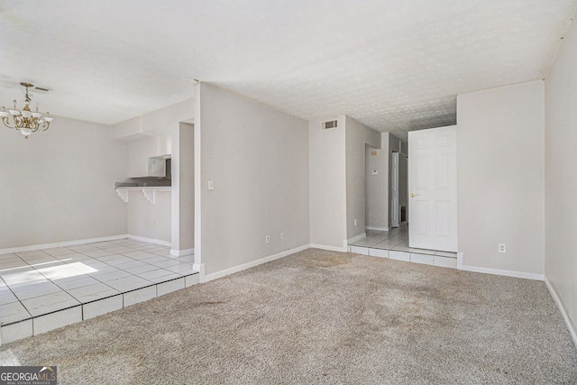 unfurnished living room featuring light carpet, a textured ceiling, visible vents, and a notable chandelier