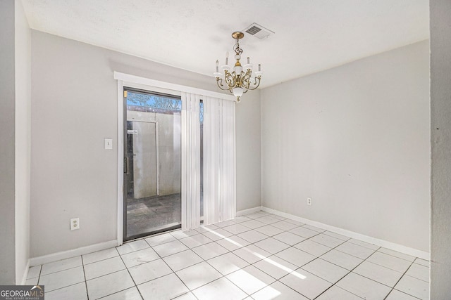 unfurnished room with an inviting chandelier, baseboards, light tile patterned floors, and visible vents