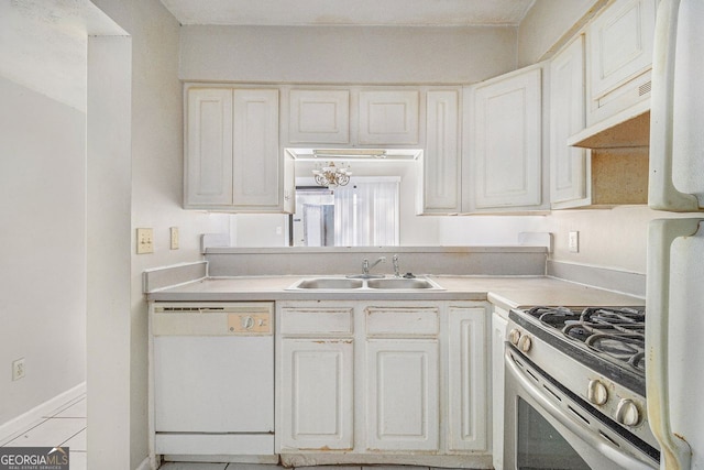 kitchen featuring stainless steel gas range oven, white dishwasher, a sink, white cabinets, and light countertops