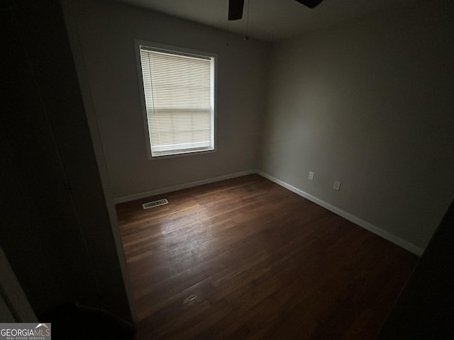 empty room featuring ceiling fan and dark wood-type flooring