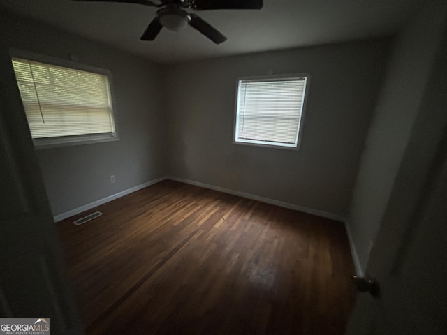 spare room featuring dark hardwood / wood-style flooring and ceiling fan