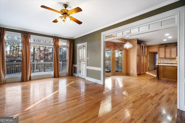 interior space with ceiling fan with notable chandelier, light hardwood / wood-style floors, and crown molding