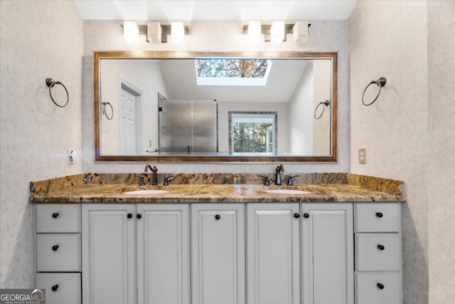 bathroom featuring vanity and lofted ceiling with skylight