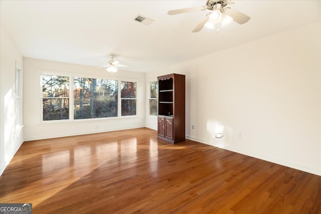 empty room with ceiling fan and hardwood / wood-style floors