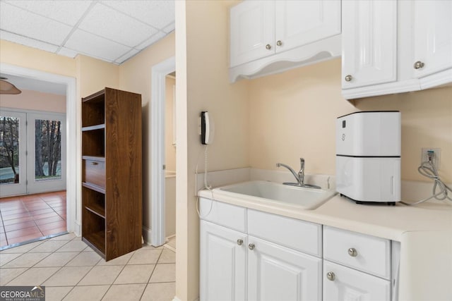 kitchen with sink, white cabinets, and light tile patterned flooring