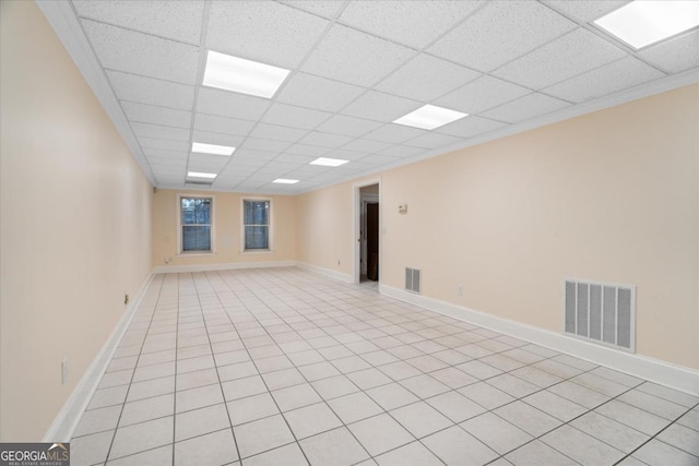 unfurnished room with a drop ceiling and light tile patterned floors