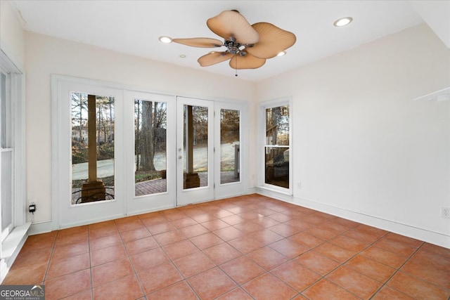 unfurnished sunroom featuring a wealth of natural light and ceiling fan