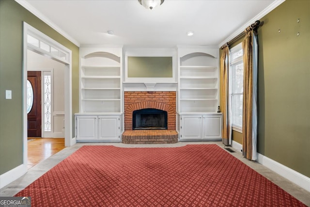 unfurnished living room featuring built in shelves, crown molding, and a fireplace