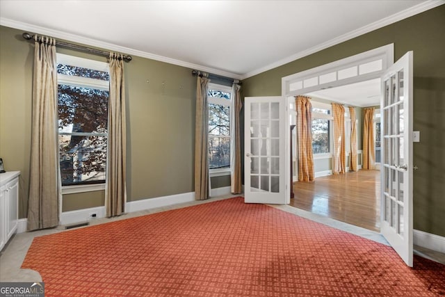 spare room featuring light hardwood / wood-style floors, crown molding, and french doors