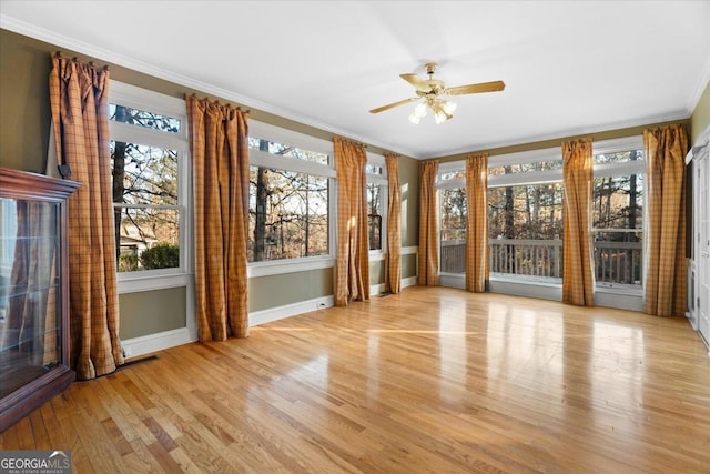 unfurnished sunroom with ceiling fan