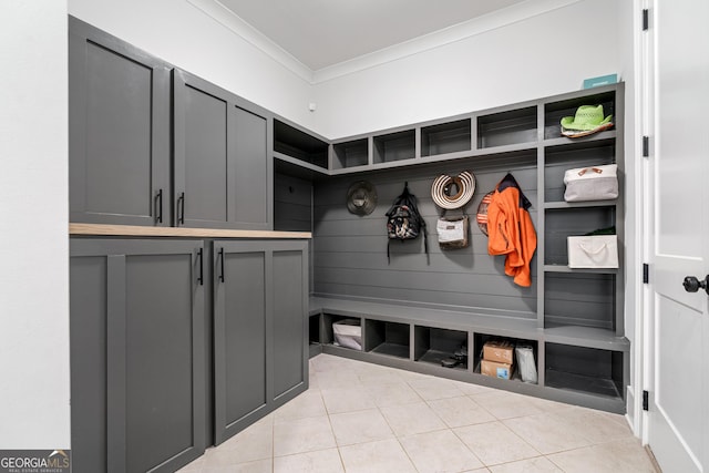 mudroom with crown molding and light tile patterned flooring