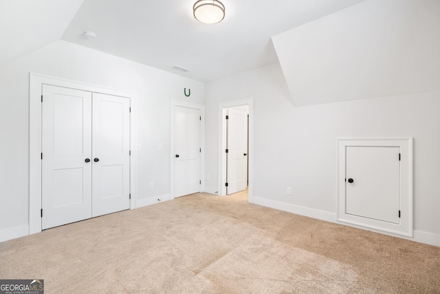 additional living space featuring light carpet and vaulted ceiling