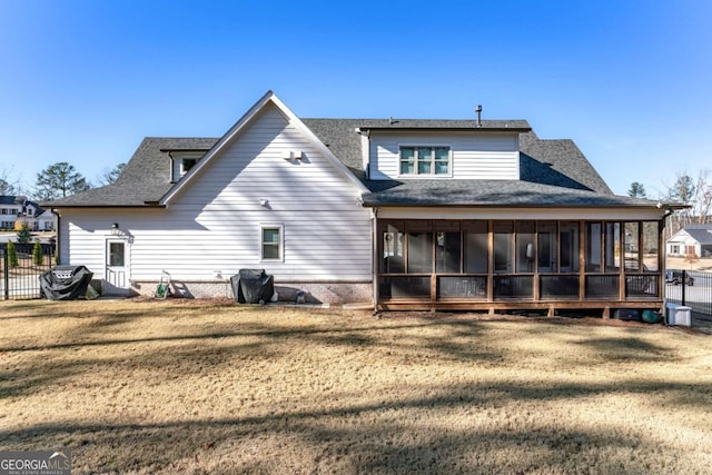 rear view of property featuring a sunroom and a yard