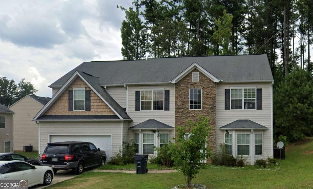 view of front of house with a front yard and a garage