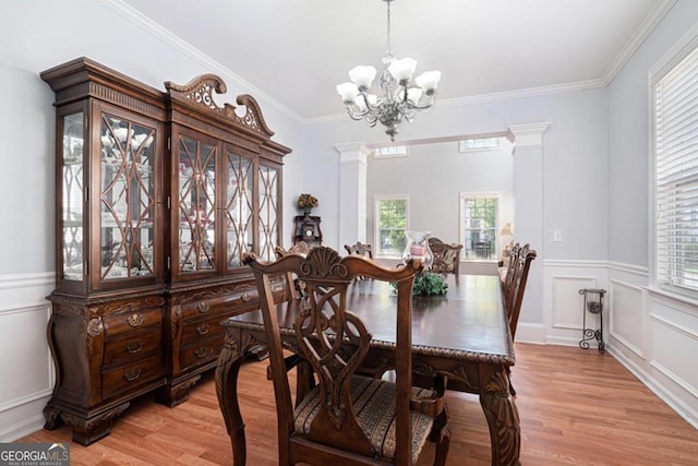 dining area featuring ornate columns, light hardwood / wood-style flooring, and a healthy amount of sunlight