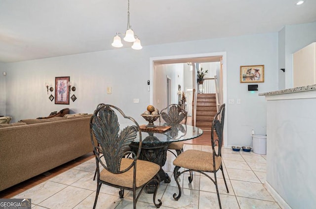 tiled dining room featuring a chandelier