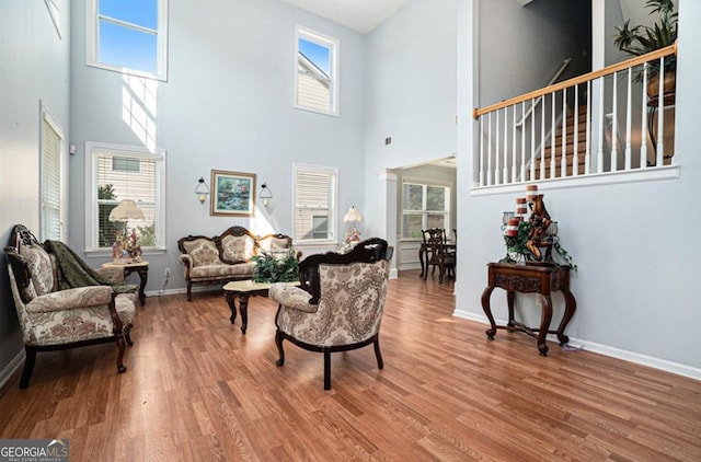 living room with hardwood / wood-style floors and a towering ceiling