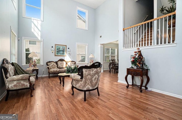 living room with hardwood / wood-style flooring and a towering ceiling