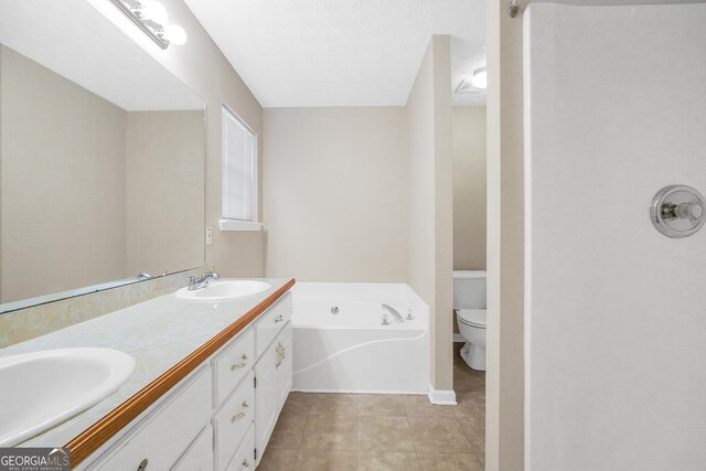 bathroom with a bathing tub, tile patterned flooring, vanity, and toilet