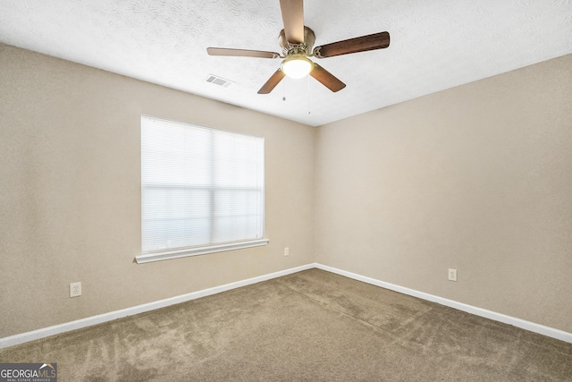 carpeted empty room featuring a textured ceiling and ceiling fan