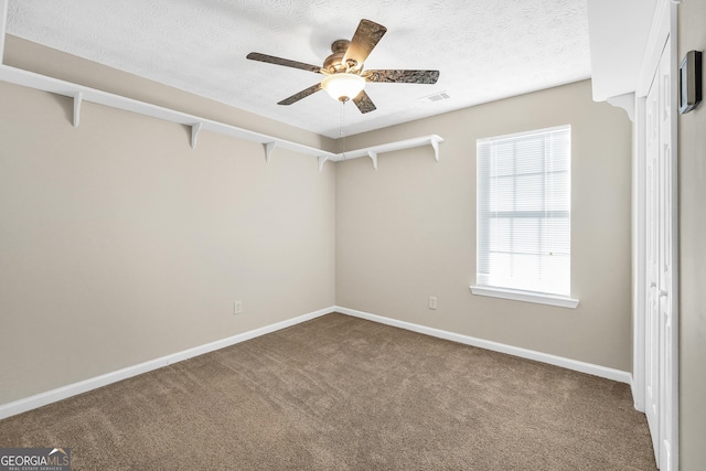 spare room with carpet flooring, a textured ceiling, and ceiling fan