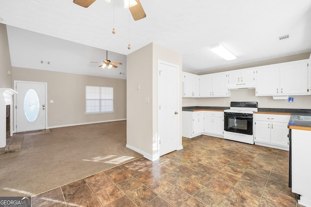 kitchen featuring vaulted ceiling, white range with electric stovetop, ceiling fan, dark colored carpet, and white cabinets