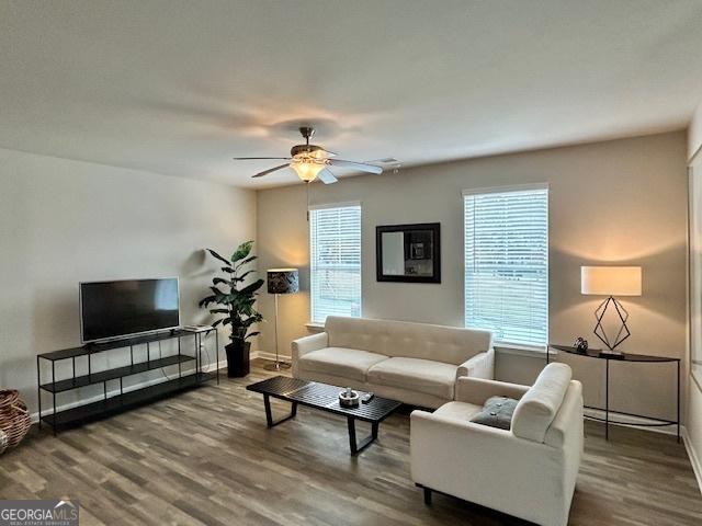 living room with wood-type flooring and ceiling fan