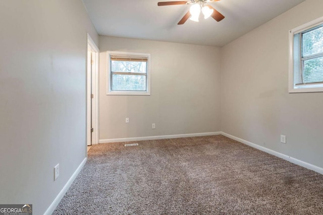 carpeted spare room with ceiling fan