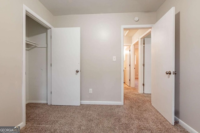 unfurnished bedroom with light carpet and a closet