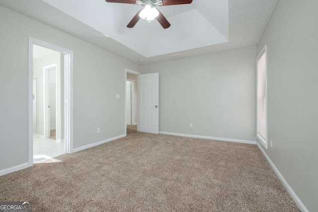 unfurnished bedroom with carpet flooring, ceiling fan, and a tray ceiling