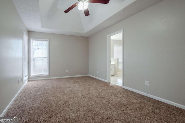 spare room featuring carpet, a textured ceiling, a raised ceiling, and ceiling fan