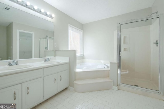 bathroom with tile patterned floors, vanity, and separate shower and tub