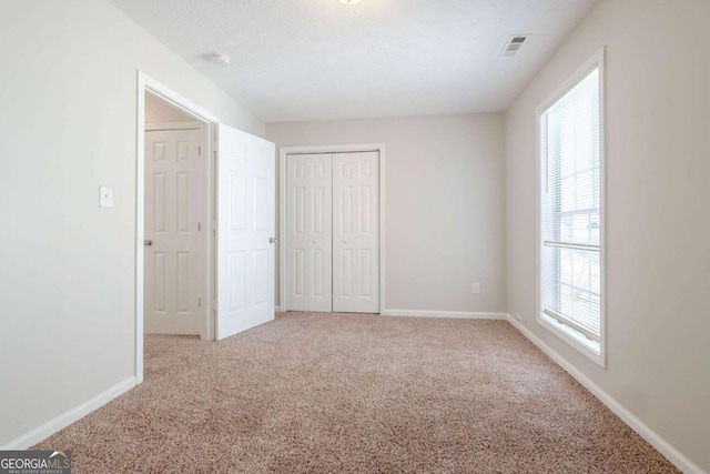 unfurnished bedroom with carpet flooring and a closet