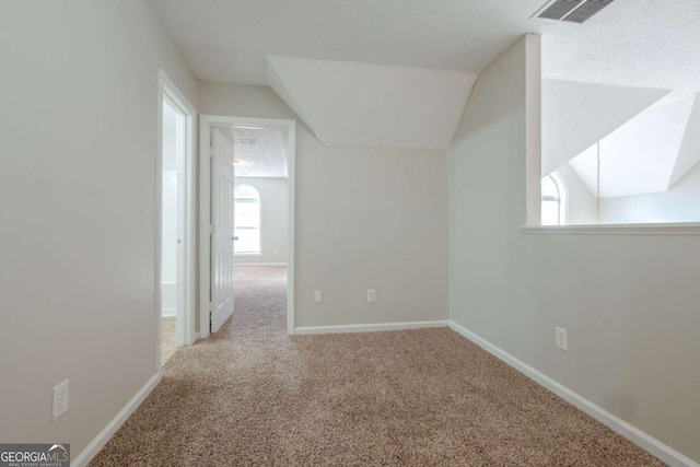 bonus room with light carpet and lofted ceiling