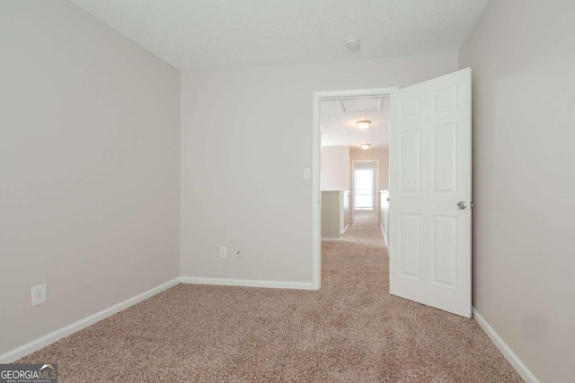 carpeted spare room with a textured ceiling