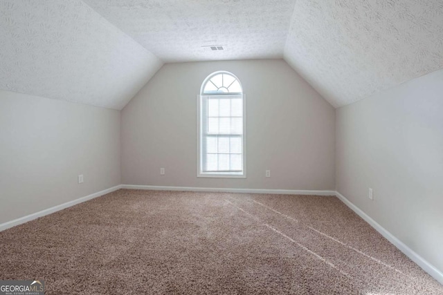 bonus room with carpet flooring, a textured ceiling, and vaulted ceiling