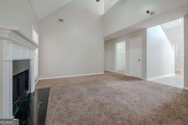 unfurnished living room featuring carpet floors, a fireplace, and high vaulted ceiling