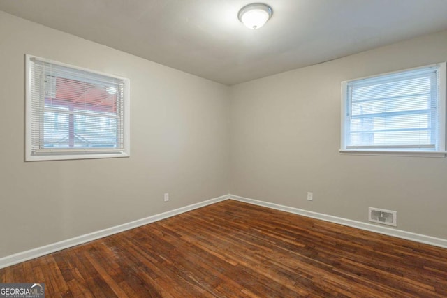 empty room with dark hardwood / wood-style flooring